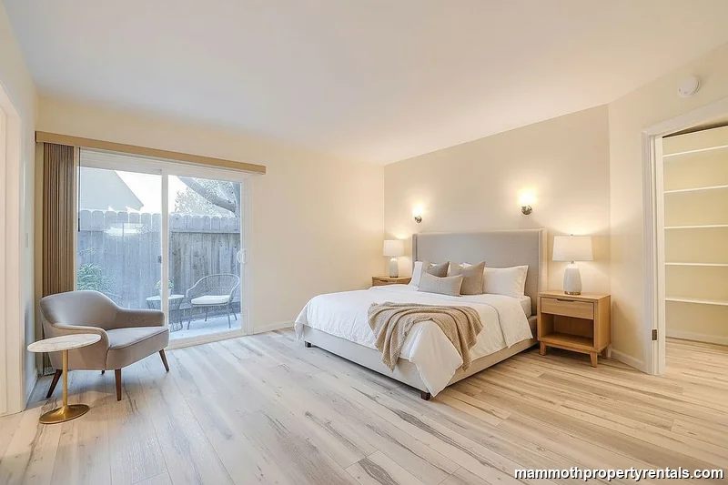 Spacious master bedroom with large windows and wide-plank flooring.